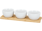 Conjunto de três tigelas brancas para molho em uma bandeja de bambu.