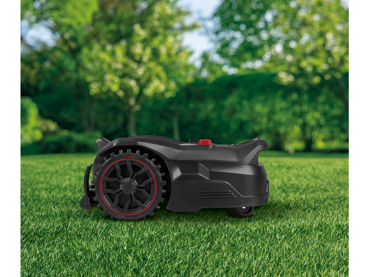 PARKSIDE PERFORMANCE® 20V Robot Lawn Mower on green grass with blurred trees in background.