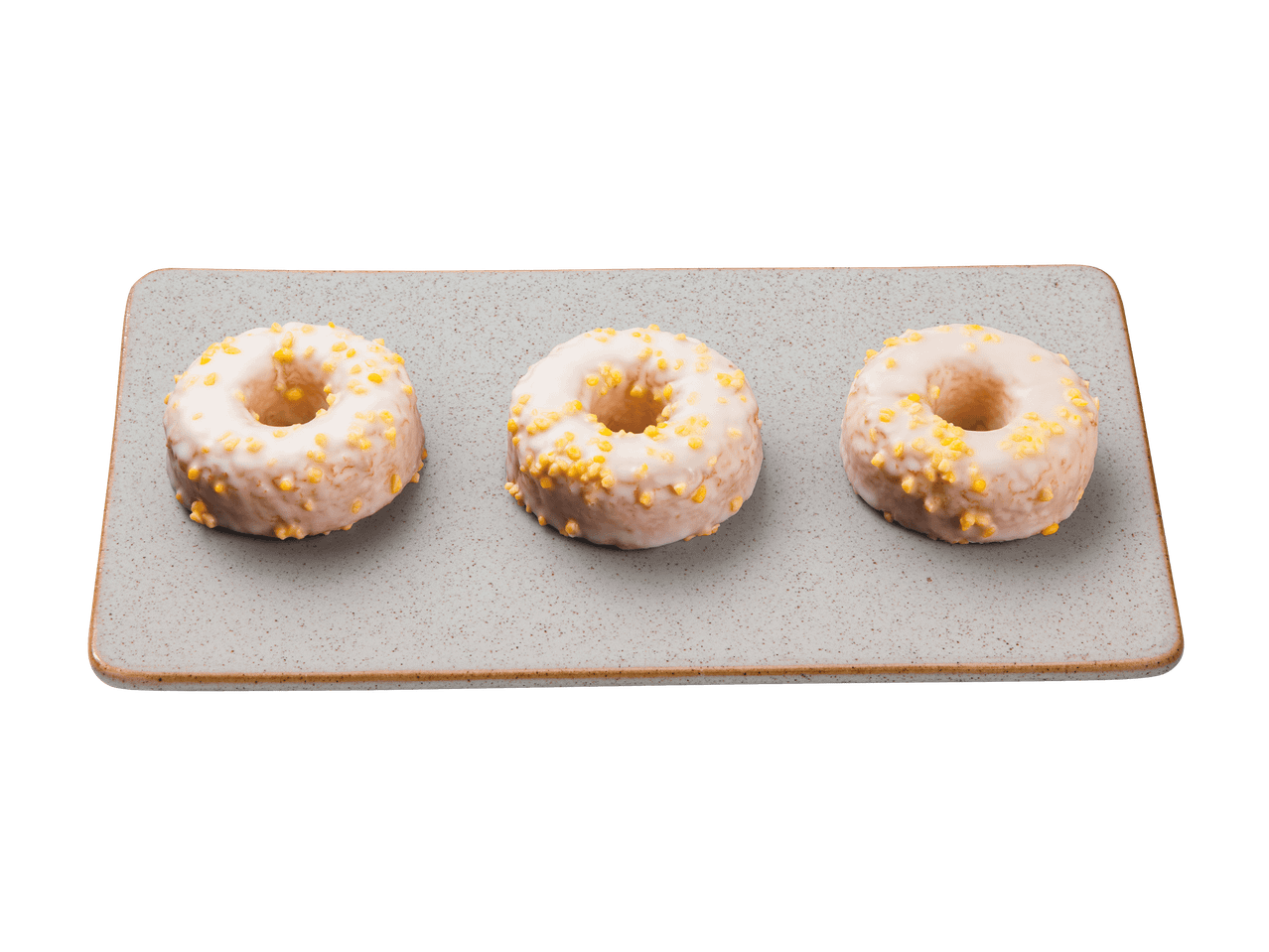 Trois donuts glacés avec des pépites jaunes sur un plateau rectangulaire.