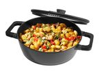 Black cooking pot with gnocchi, zucchini, mushrooms, and tomatoes, with a tilted lid.