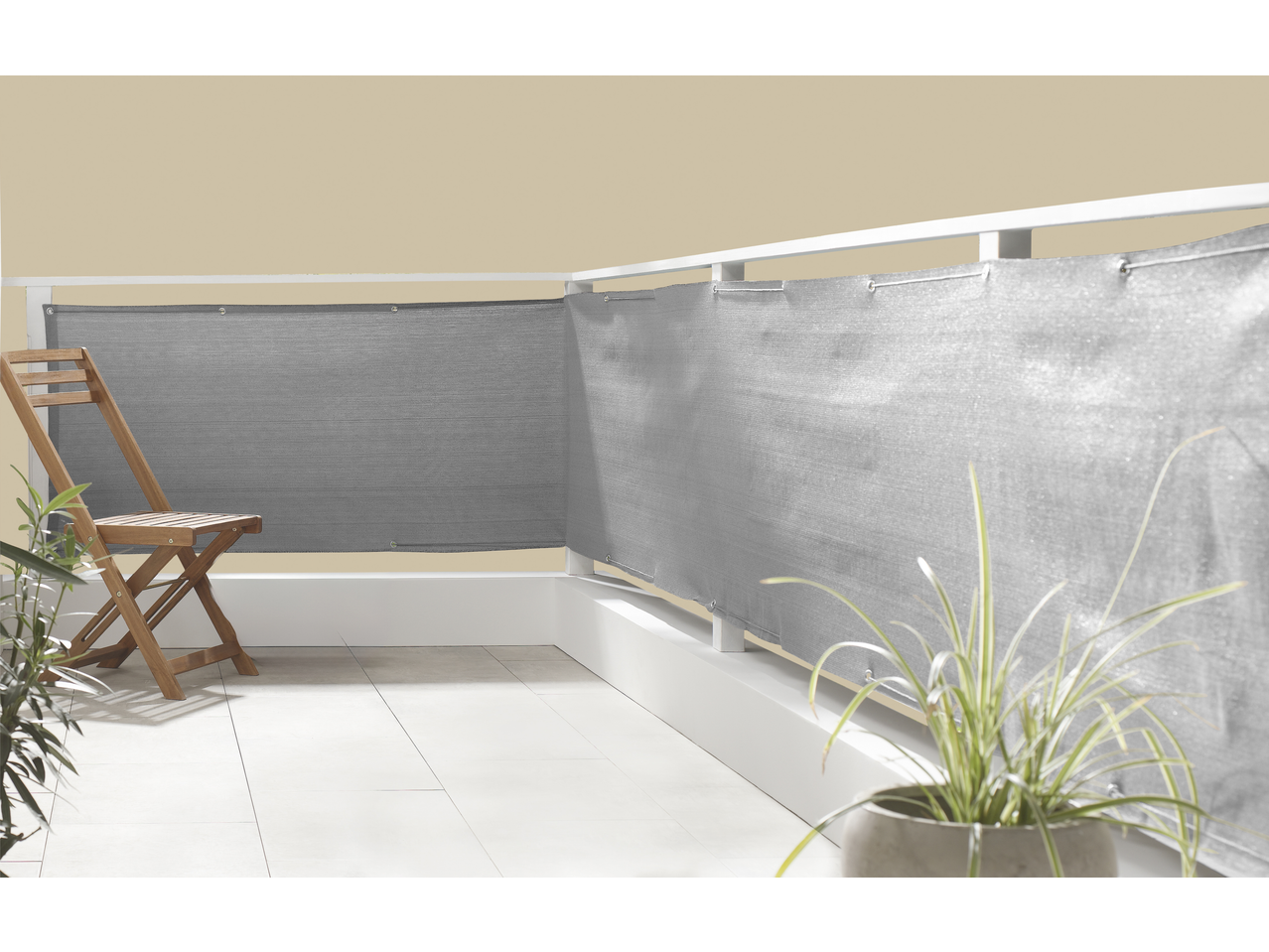 Balcon cu paravan de confidențialitate gri, scaun din lemn și plante în ghivece.