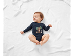A baby wearing a dark blue long-sleeved bodysuit with a forest animal print.