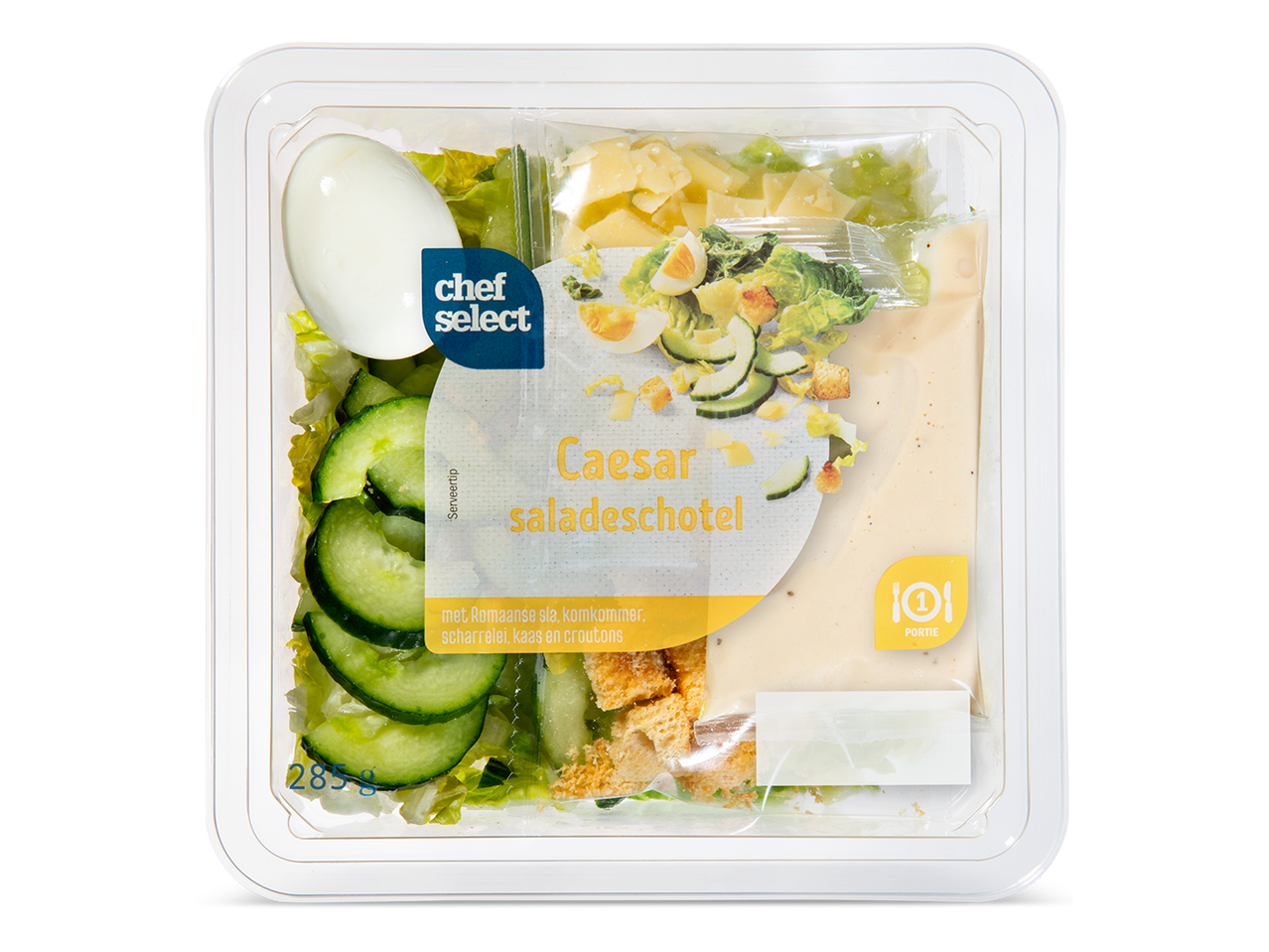 Een Caesar saladeschotel met Romeinse sla, komkommer, ei, kaas en croutons in een plastic verpakking.
