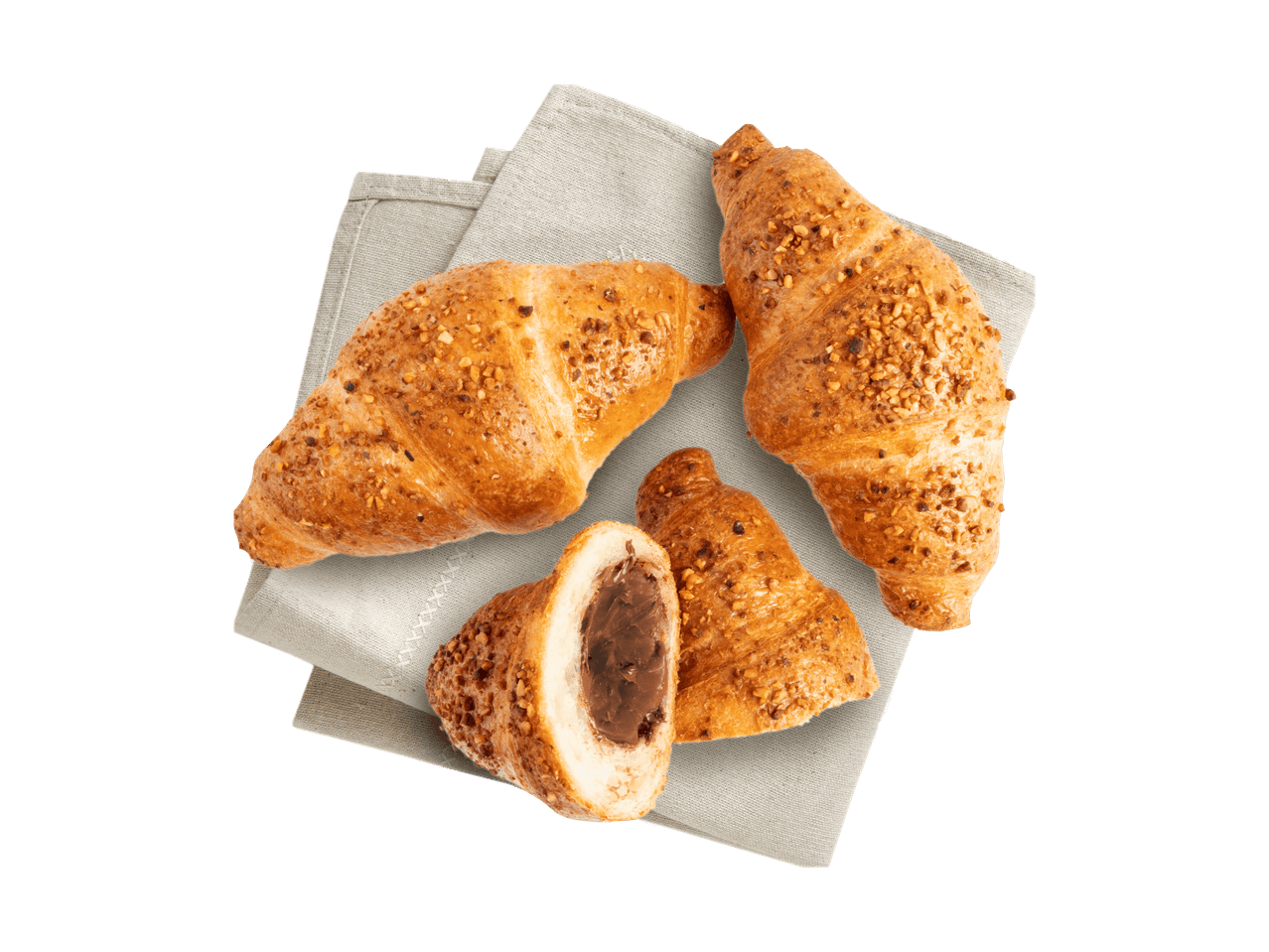 Drei Haselnuss-Croissants, eines davon mit Schokoladenfüllung, auf einem Leinentuch.