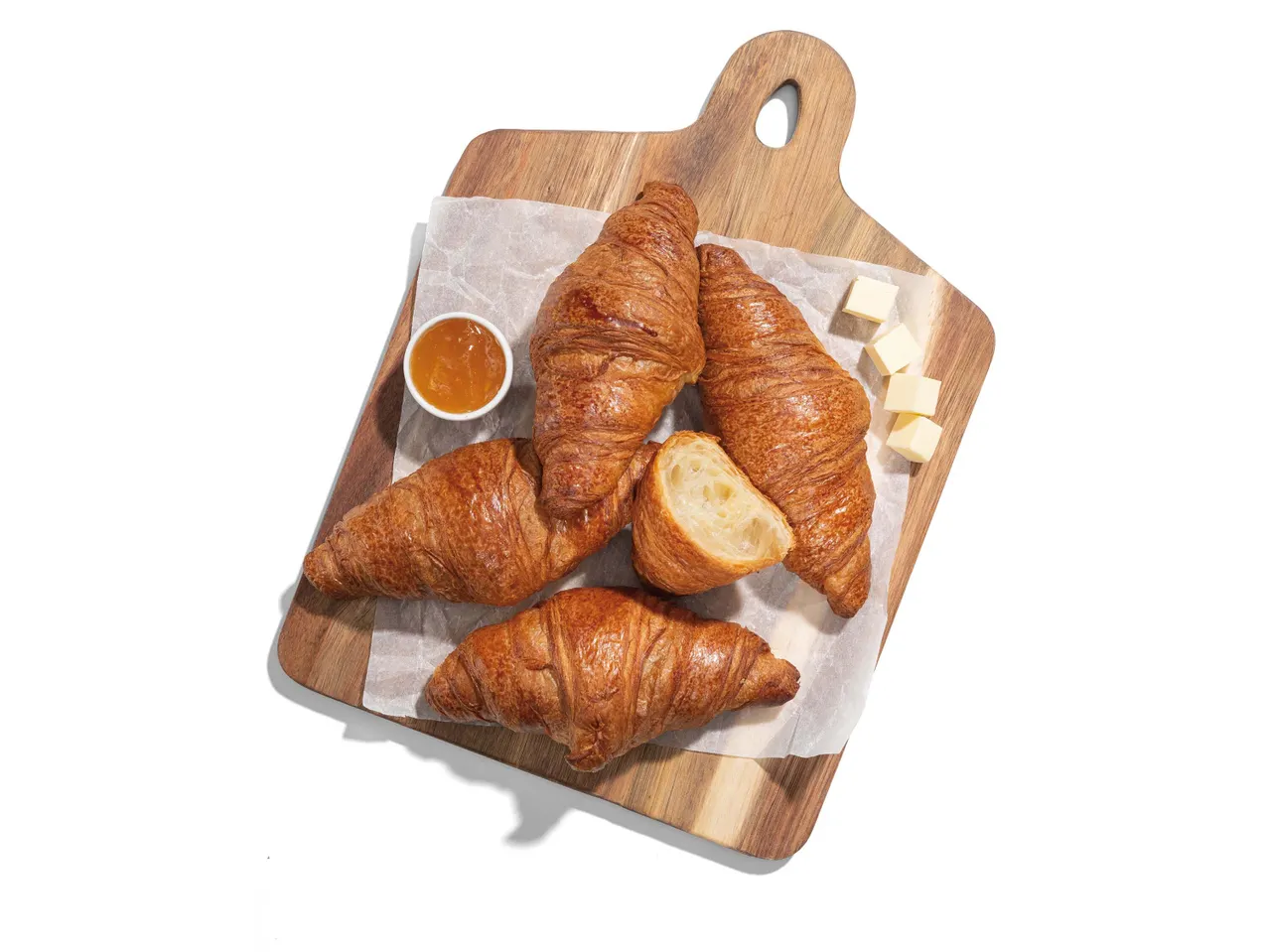 Croissant-ok, vaj és lekvár fa táblán.