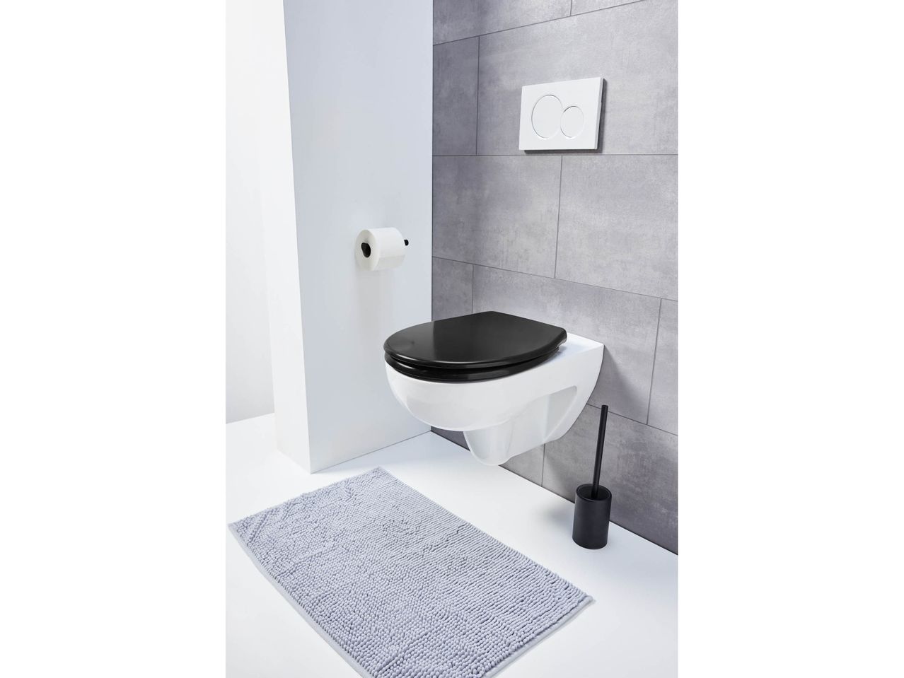 Modern bathroom with a wall-mounted toilet, black seat, and gray bath mat.