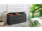 A black outdoor storage box with gardening tools and a hose inside, on a patio.