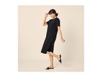 Woman in a black midi dress and black sandals, smiling and posing playfully.