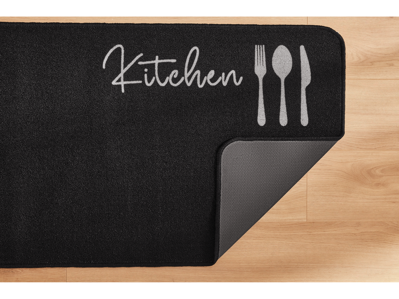 Juoda virtuvės kilimėlis su užrašu 'Kitchen' ir stalo įrankiais.
