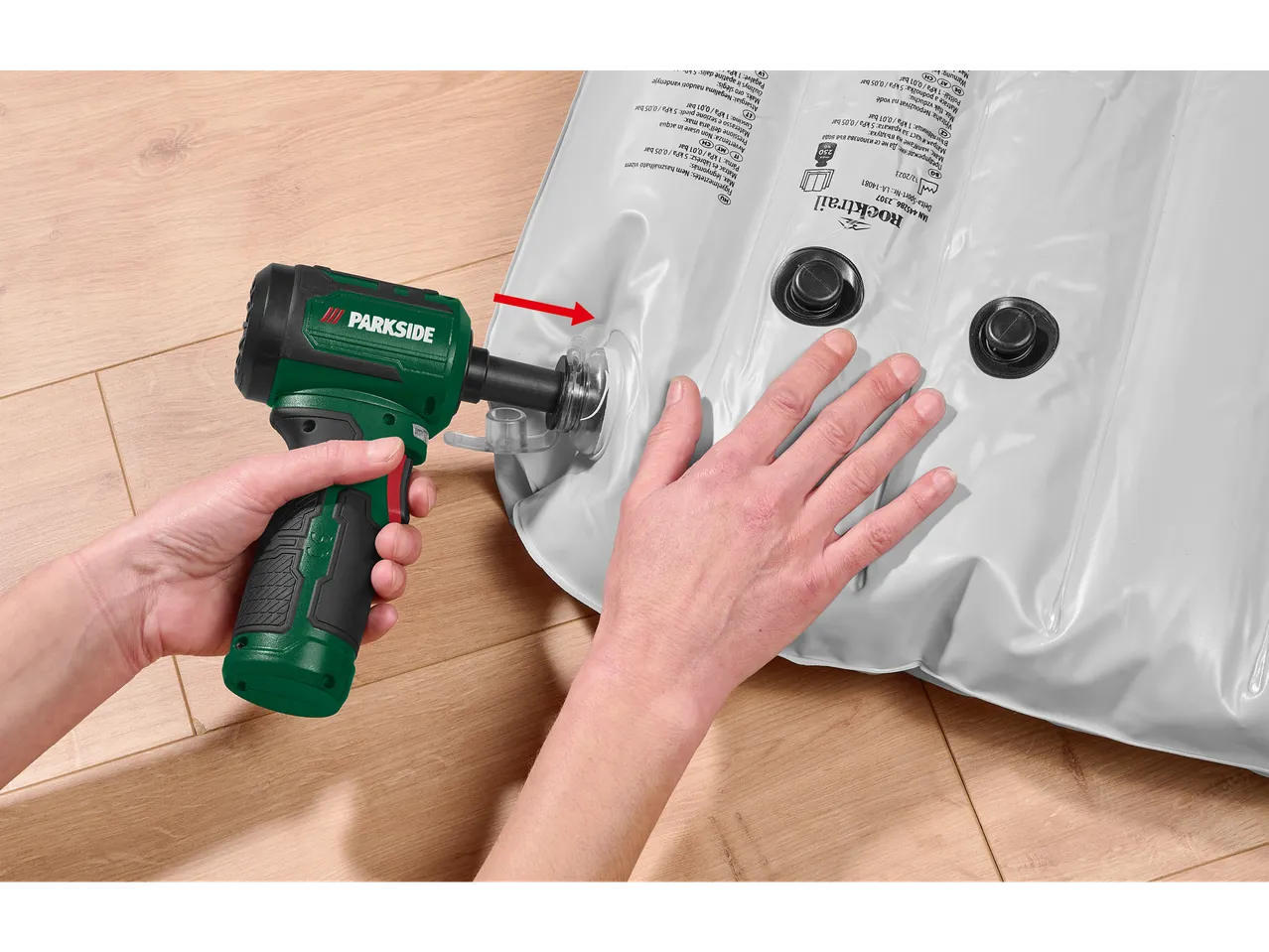 Person using a Parkside 12V cordless mini blower to inflate a Rocktrail air mattress.