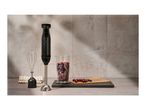 Silvercrest hand blender with whisk, measuring cup of berries, and berries on a board.