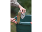 A person applying 3M duct tape to a green bucket.