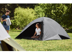 Man holding a CRIVIT sleeping bag, woman sitting inside a CRIVIT 4 Person Blackout Tent.