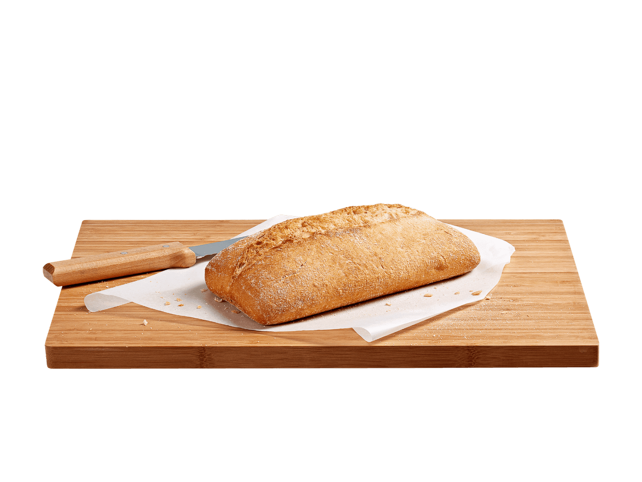 Una pagnotta di pane su un tagliere di legno con un coltello da pane e carta da forno.