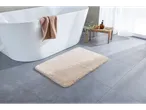 Livarno Home bež prostirka za kupatilo ispred bele kade