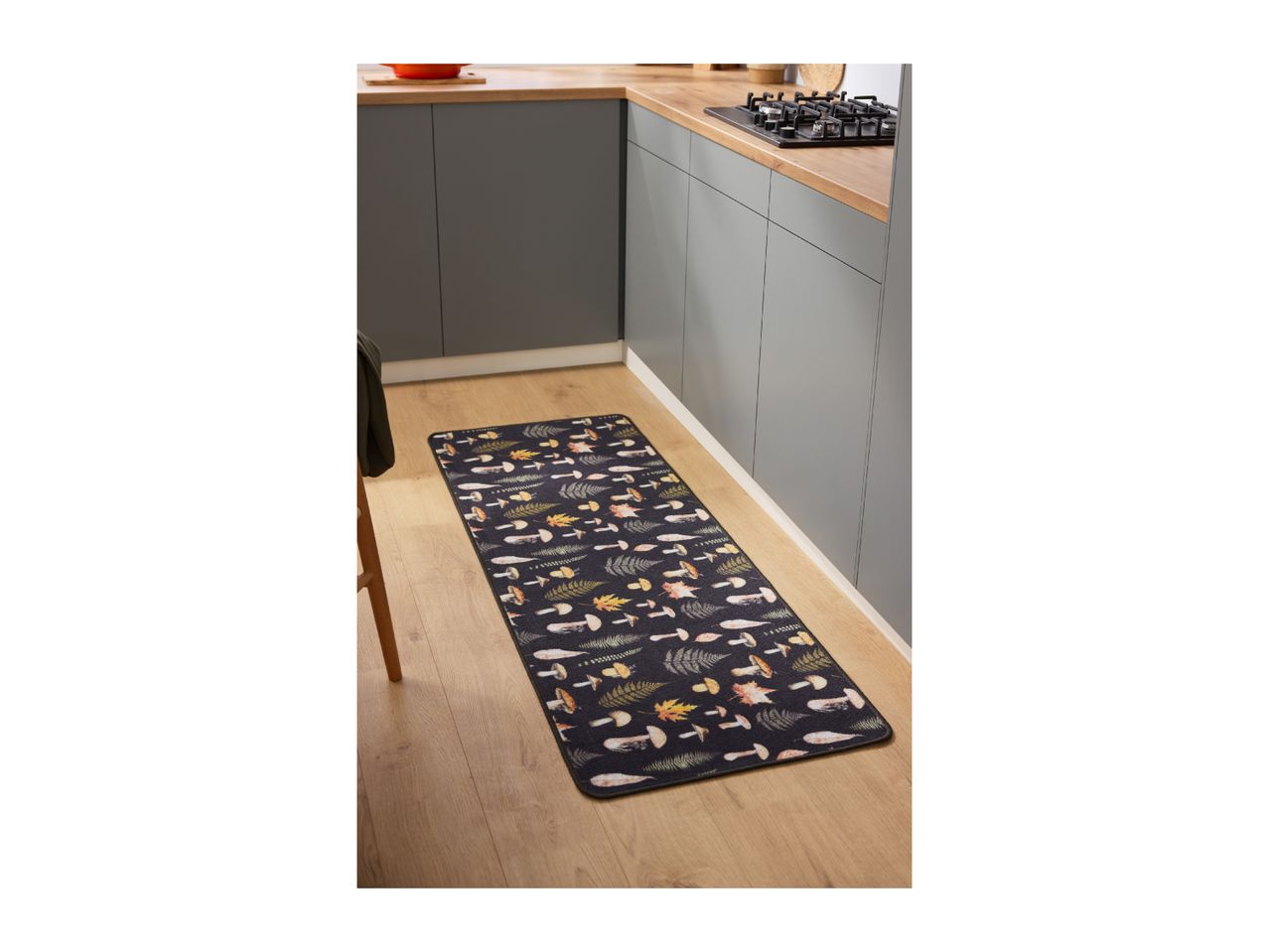 Kitchen runner with mushroom and leaf pattern on a wooden floor in a modern kitchen.