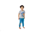 Criança sorridente em pijama cinzento e azul com motivo de dinossauro.