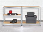 Two metal shelving units with various items, including work boots, a tool case, and storage boxes.