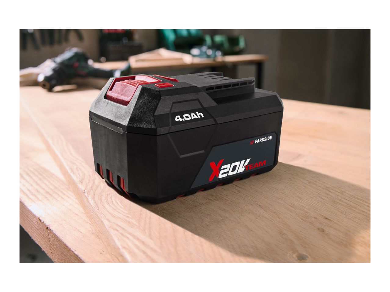 A black and red power tool battery with '4.0Ah' and '20V Team' on a wooden surface.