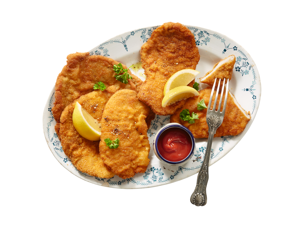 Gebakken schnitzels, citroen en ketchup.
