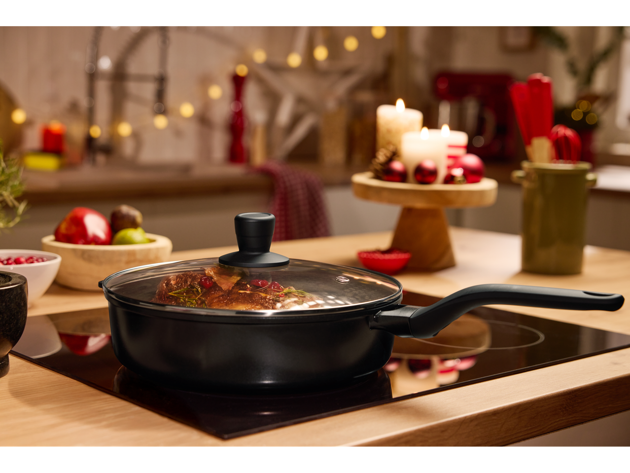 SILVERCREST® Cast Aluminium Sauté Pan on an induction hob in a festive kitchen.