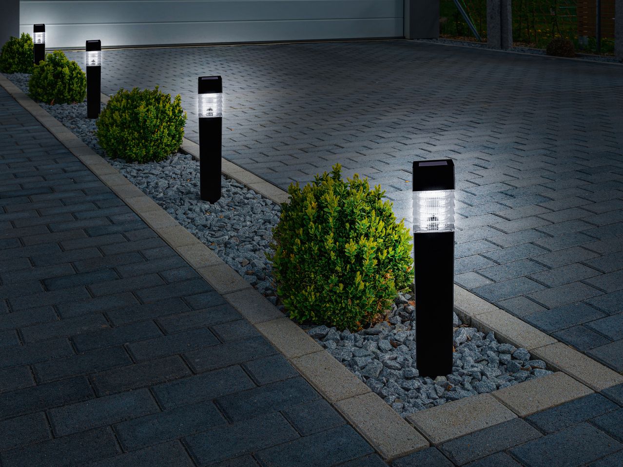 LED соларни лампи Livarno Home, подредени в градинка до къщата.