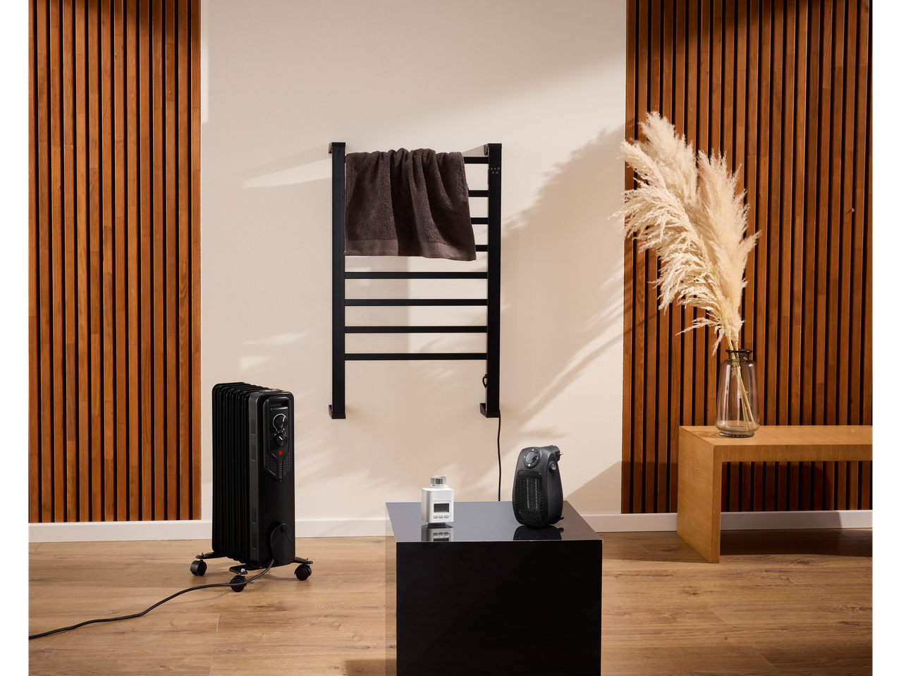 Toalheiro elétrico Tronic® com radiador e aquecedor portátil num quarto moderno