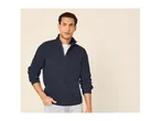 A man wearing a dark blue ribbed half-zip sweater over a white t-shirt and light jeans.
