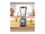 A SilverCrest blender with ice, a drink, and limes on a wooden counter.