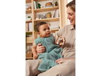 Mother and baby with wooden rattle and baby sleeping bag.