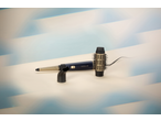 Hair styler with interchangeable brush and concentrator attachments on a light background.