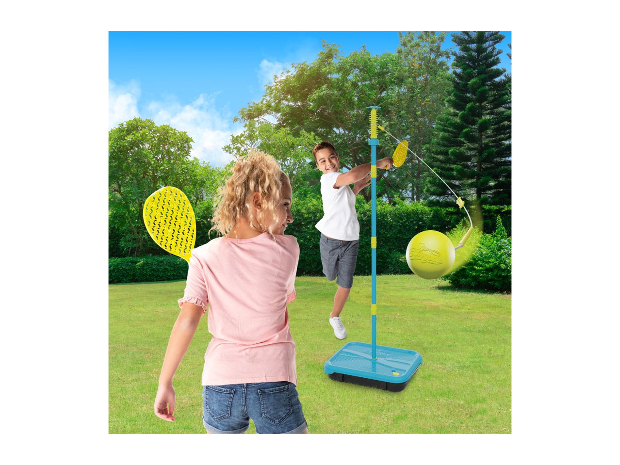 Two children playing an outdoor swingball game with rackets in a sunny garden.
