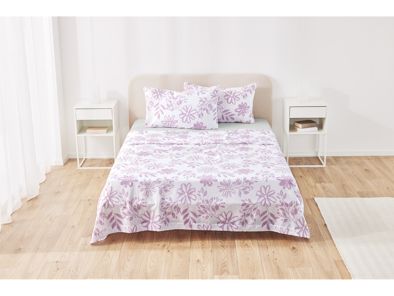 Purple floral patterned bedding in a white bedroom