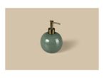 Round green soap dispenser with a gold pump on a beige background