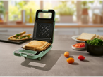 Un sandviș prăjit într-un toaster verde deschis.