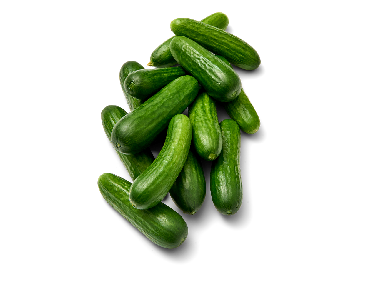 Een stapel verse groene komkommers op een zwarte achtergrond.