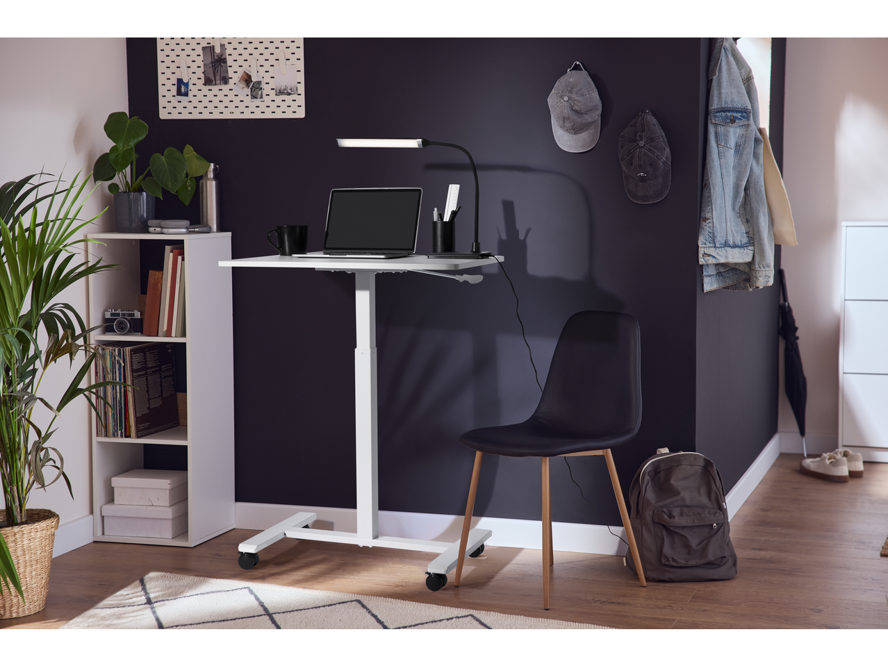 Secretária com portátil e candeeiro LED LIVARNO, cadeira, prateleira com plantas e decorações.