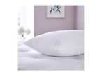 A white pillow with a subtle pattern rests on a quilted mattress in a bright room.