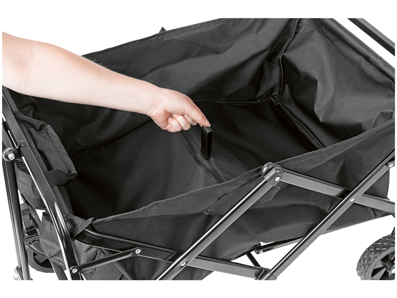 A hand adjusting the black fabric interior of a foldable utility wagon.