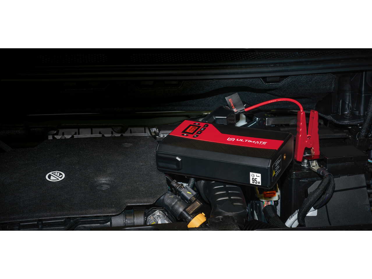 A portable Ultimate Speed jump starter connected to a car battery.