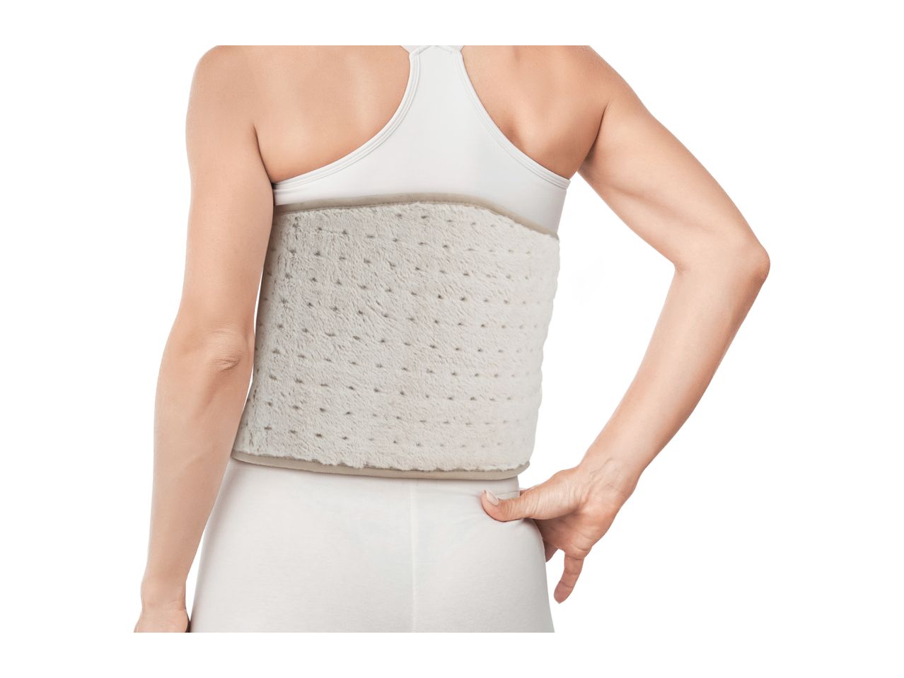 Woman wearing a beige back warmer, holding her lower back with one hand