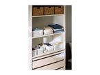 Organized closet with woven baskets, folded clothes, and white storage boxes for accessories.