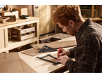 Man using Parkside® Measuring Assortment tools to mark wood in a workshop.