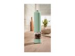 Mint green electric pepper mill with mixed peppercorns on a kitchen counter.