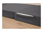 Dark gray foldable mattress with an exposed zipper and white foam interior on a wooden floor.