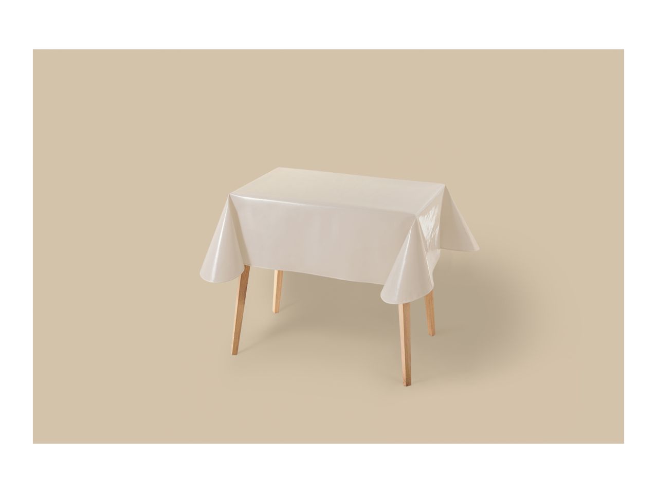 A rectangular table with light wooden legs, covered with a plain, light-colored tablecloth.