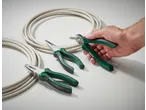 Parkside: Set of three pliers with green handles and electrical cable, hand stripping cable.