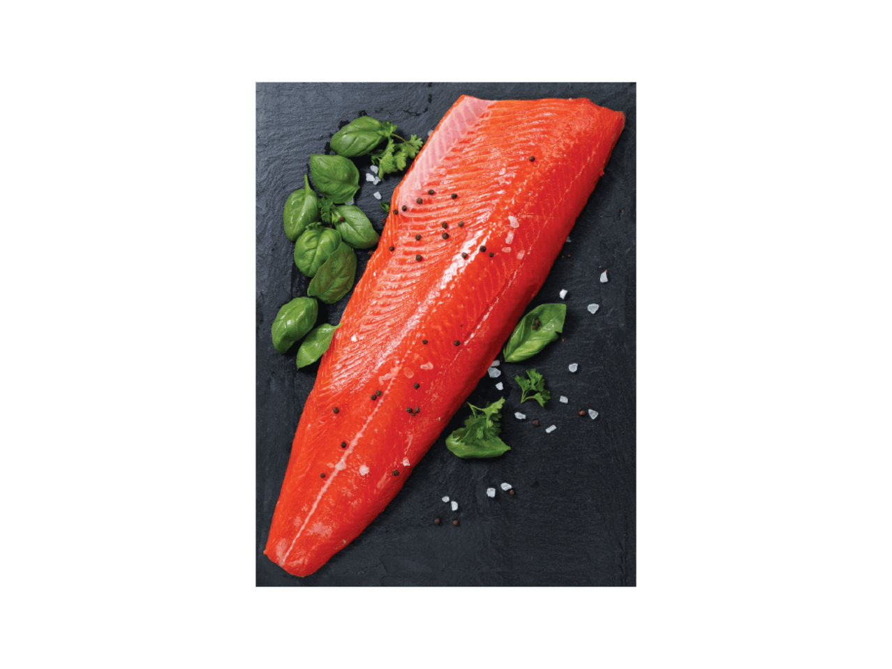 Toores lõhefilee mustal laual, maitsestatud pipra, soola ja basiilikuga.