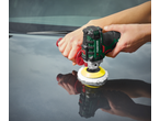 Person polishing a car with a handheld polisher with a yellow pad.