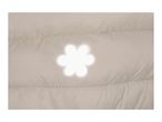 Close-up of a beige quilted jacket with a white flower-shaped reflector.